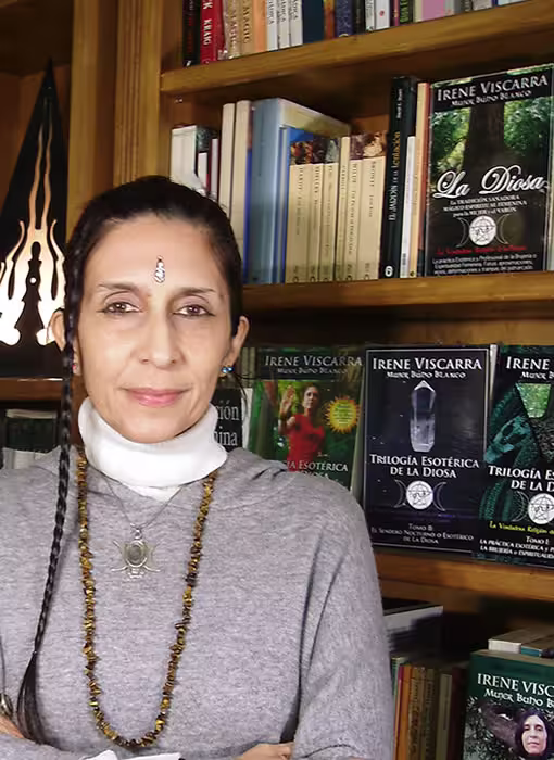Irene Viscarra Mujer Búho Blanco en Librería Esotérica de La Diosa Irene Viscarra Mujer Búho Blanco Bruja Adepta Grado 3 junto a los estantes de libros esotéricos físicos y originales